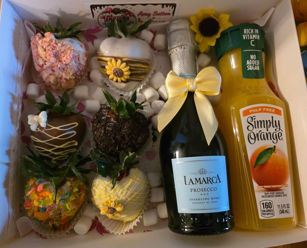 Mimosa gift box with decorated chocolate covered strawberries, prosecco, and orange juice